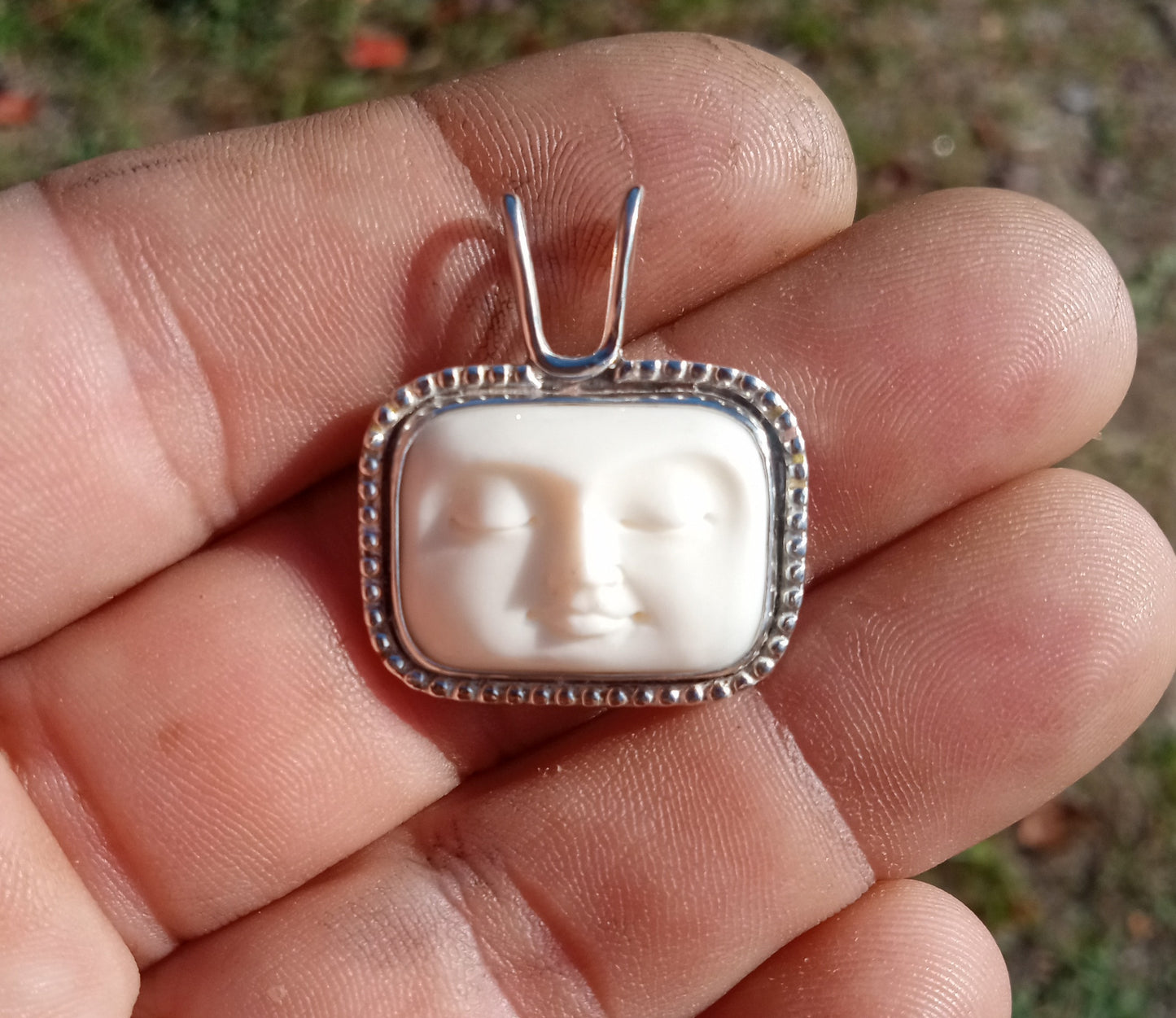 Beautiful hand carved bone moon face and fine silver pendant