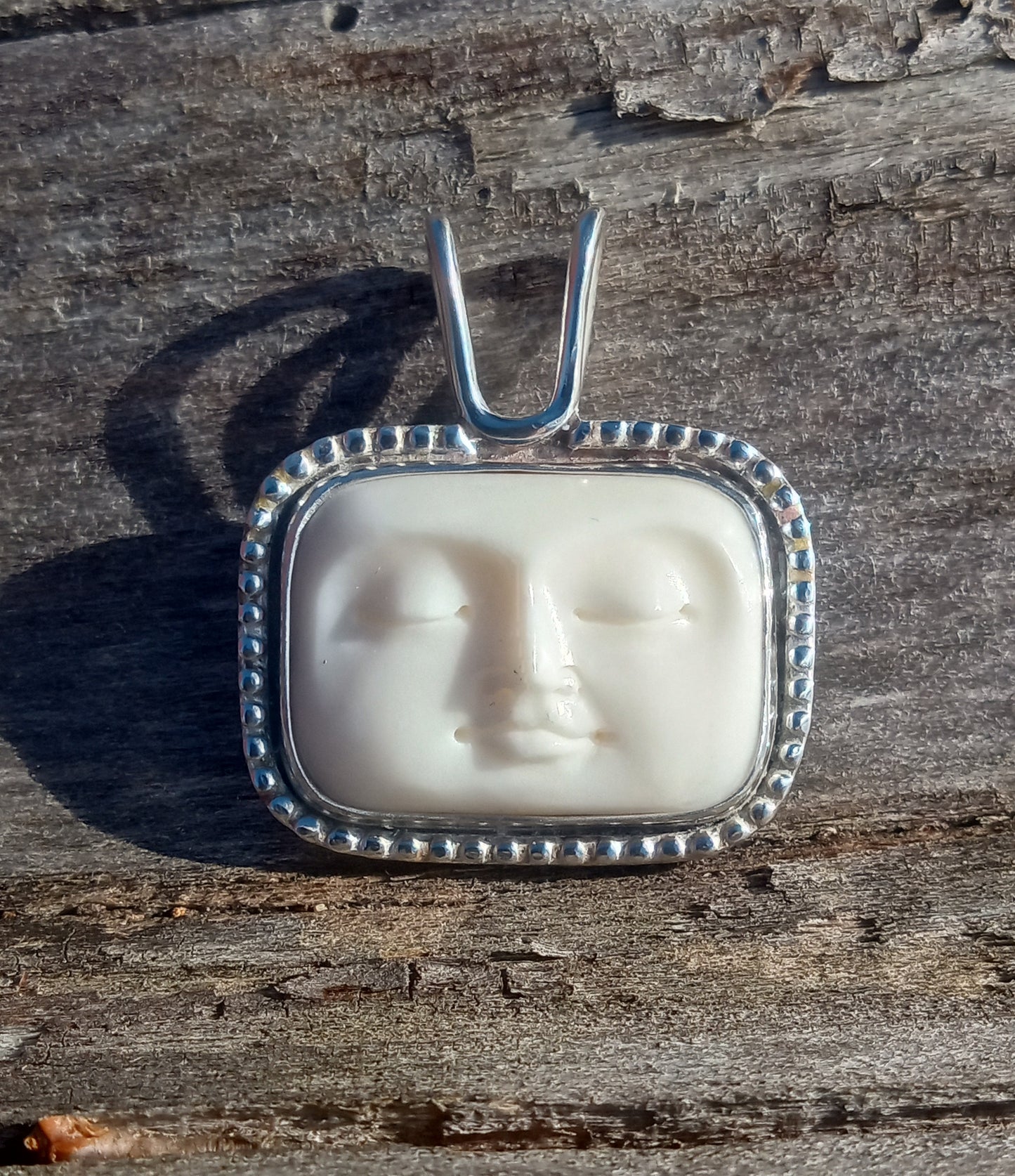 Beautiful hand carved bone moon face and fine silver pendant